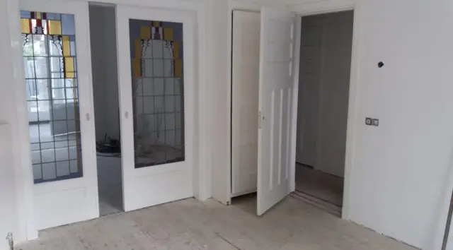 Wit gelakte binnendeuren en suite met glas-in-lood, met strak gespoten witte wanden